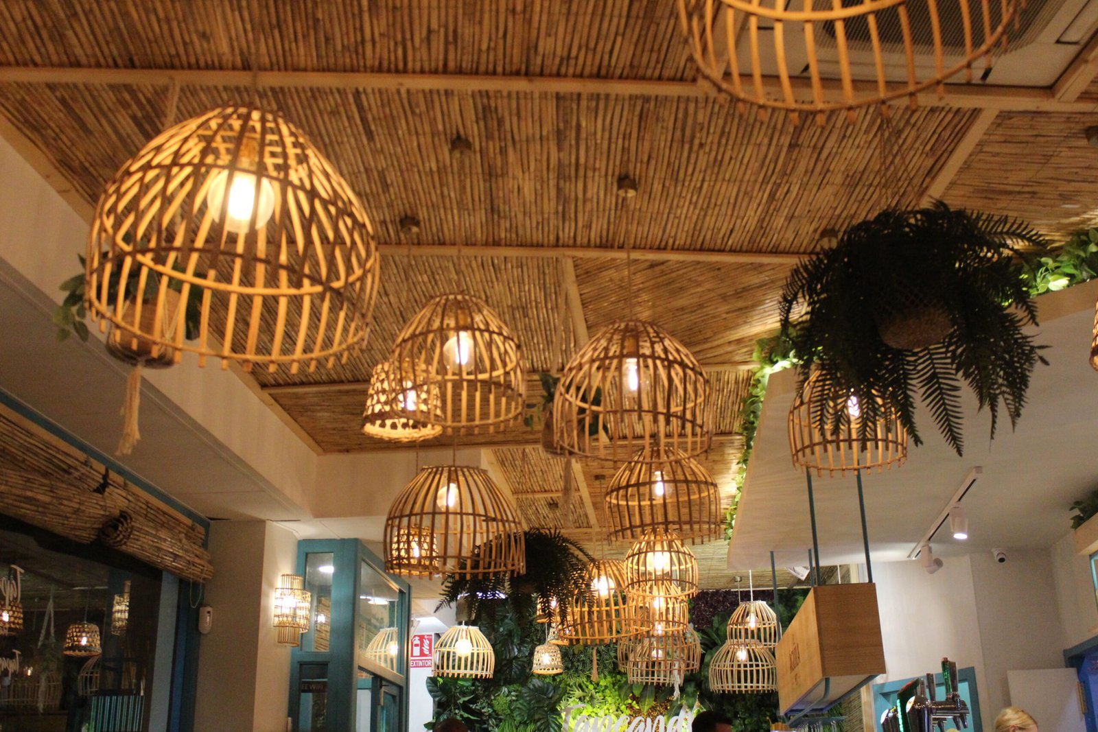 A low angle of wicker lamps and ceiling inside the building